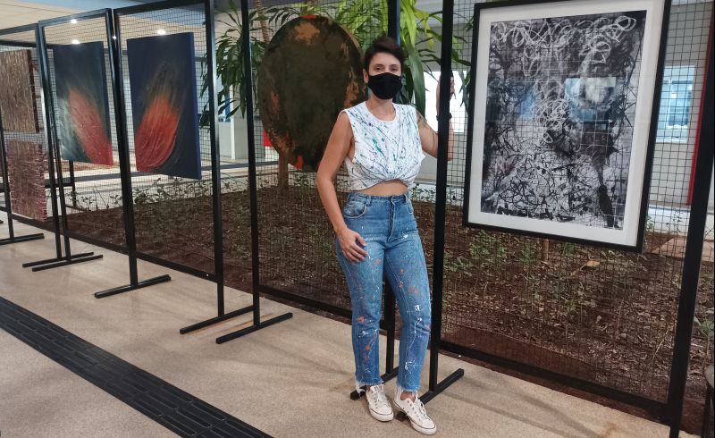 A artista Andressa Martins com suas obras (Foto: Reprodução/Uberlândia)